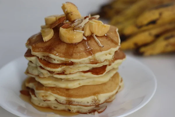 Plantain buttermilk pancakes. Soft and fluffy buttermilk pancake made with a batter added with slices of ripe plantain. Served with chopped almonds, sliced plantain and a drizzle of honey