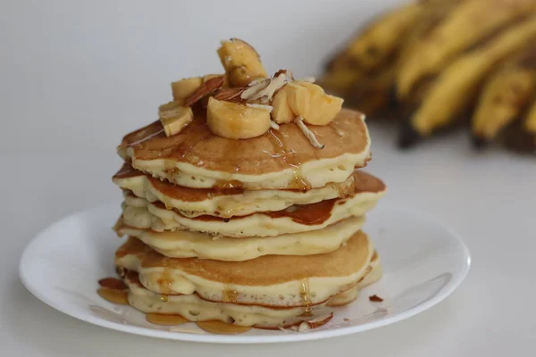 Plantain buttermilk pancakes. Soft and fluffy buttermilk pancake made with a batter added with slices of ripe plantain. Served with chopped almonds, sliced plantain and a drizzle of honey