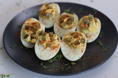 Stuffed eggs. Hard boiled eggs cut into half and stuffed with a paste made with egg yoks, mixed with mayonnaise and mustard. It is also known as Angel eggs, dressed eggs, devilled eggs. clipart