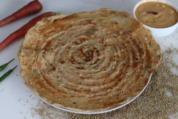 stock image Carrot bajra ghee roast. Crispy crapes made of fermented batter of unpolished pearl millets and de husked black lentils with freshly grated carrots added into the batter. Served with coconut chutney