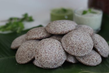 Ragi boş boş oturuyor. Yeşil hindistancevizi soslu mayalanmış siyah mercimek ve parmak değirmeni hamuru hamuru tarafından yapılan buğulanmış lezzetli pirinç keki. Arkaplan olarak yeşil muz yaprağı üzerinde çekim