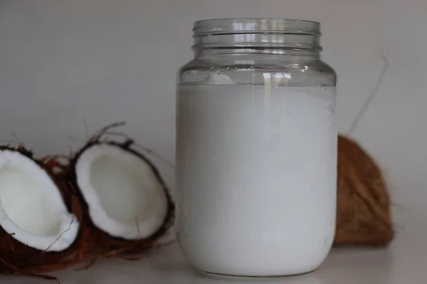 Frozen coconut oil in a glass bottle taken from refrigerator. Coconut oil is a cooking oil which freezes in the winter or in cold because it has a low melting point
