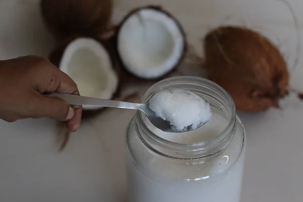 Frozen coconut oil in a glass bottle taken from refrigerator. Coconut oil is a cooking oil which freezes in the winter or in cold because it has a low melting point
