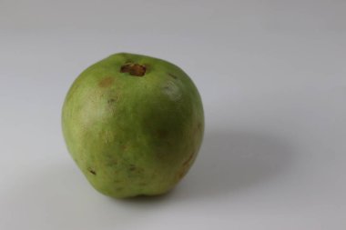 Guava meyvesi. Açık yeşil engebeli derisi ve kırmızı veya sarı renkli eti olan armut şeklinde küçük bir meyvedir. Mükemmel bir beslenme lifi ve besin kaynağıdır. Beyaz arkaplanda çekilen