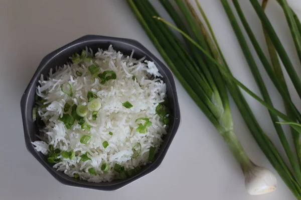 Butter rice or Spiced rice with spring onions. Boiled basmati rice garnished with chopped green onions. Shot on white background.