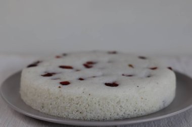 Vattayappam. Kurutulmuş yaban mersinli buğulanmış pirinç keki. Kerala 'dan geleneksel çay saati aperatifi mayalanmış pirinç ve hindistan cevizi hamuru ile hazırlanır ve genellikle yuvarlak bir tabakta pişirilir..