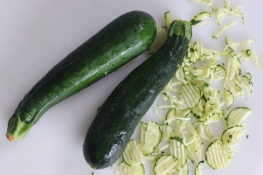 Gür, yeşil kabak, kabak türleri sebze ya da başka bir deyişle bebek iliği, parçalanmış kabak kabağıyla birlikte beyaz arka planda fotoğraflanmış..