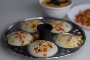 Hint cevizi turşusuyla servis edilen idli mantarlı dolmalık biber. Renkli bir Güney Hindistan kahvaltısı. Mayalanmış mercimek hamuru ve dolmalık biberli pilav ile yapılan pirinç keki.