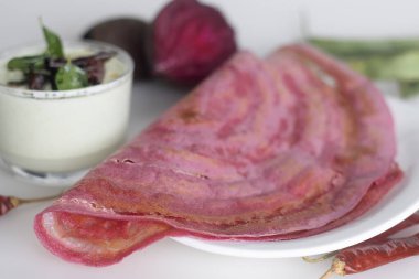 Pancar yahnisi kızartması. Mayalanmış pirinç hamuru ve pancar ezmesiyle karıştırılmış mercimek ile yapılan renkli, lezzetli Güney Hindistan gevreği. Baharatlı hindistan cevizi yeşili, soğuk baharatlı.