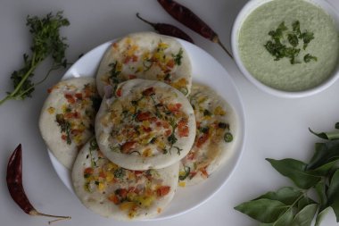 Güney Hindistan Uttapam. Mayalanmış pirinç ve mercimek hamurundan yapılmış sağlıklı bir gözleme. Üstünde soğan, havuç, kişniş ve yeşil biber var. Hindistancevizi ve yeşil soğuktan yapılmış turşuyla servis edilir.