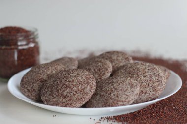 Ragi Idli. Parlak parmak darı mayalanmış hamuru ve desenli siyah gramla yapılmış besleyici bir Güney Hindistan zımbası. Gelenek ve sağlığın mükemmel bir karışımı. Yemek ve refah kavramları için iyidir.