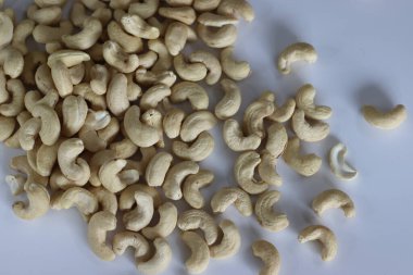 Bir yığın altın kavrulmuş kaju, aperatifler ve mutfak lezzetleri için mükemmel kaliteli ve karşı konulamaz lezzetin özünü yakalıyor. Beyaz arkaplanda çekilen