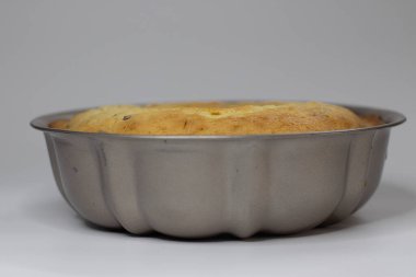 Fırından yeni çıkmış klasik tavanın içinde kızılcık portakallı kek var. Yaban mersinli ve portakallı tereyağlı lezzetli pasta. Beyaz arkaplanda çekilen