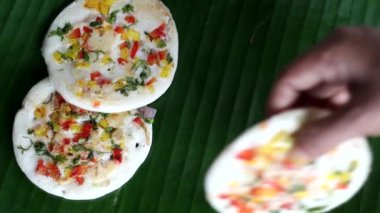 Hindistan cevizli, yeşil biberli renkli Güney Hindistan Uttapam servis ediliyor. Mayalanmış pirinç ve mercimek hamurundan yapılmış sağlıklı bir gözleme. Üstünde soğan, havuç, kişniş ve yeşil biber var.