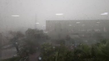 Mumbais musonunun özünü yakalıyorum. Şiddetli yaz yağmuru ve ofis penceresinden görülen güçlü rüzgarların çarpıcı görüntüsü. Bu görüntüler tropikal fırtınaların yoğunluğunu aktarmak için mükemmel.