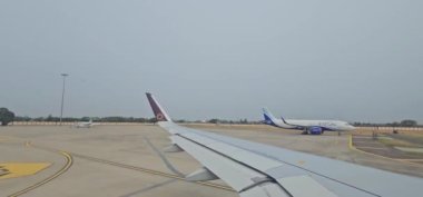 Chandigarh, Hindistan, 30 Haziran 2024: Vistara uçağı kalkış için Chandigarh havaalanında taksicilik yaparken bir Indigo uçağından geçiyor. Çivit mavisi uçağın tam görüntüsünü görebiliyor musun?