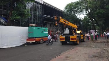 Bombay Sergi Merkezi, Mumbai, 27 Eylül 2024. Bombay Sergi Merkezi kampüsündeki inşaat halindeki bir sergi binasının önünde ilerleyişi gösteren ağır vinç montajlı kamyon görülüyor.