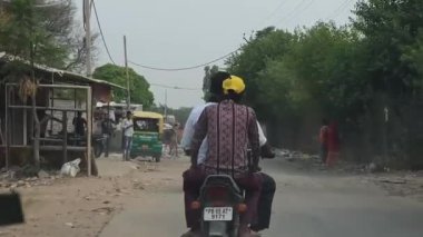 Chandigarh, 26 Haziran 2024. Bir kadın, Kandala Phirni yakınlarındaki Zirakpur yolu boyunca bisiklet arabasında geziyor. İnekler ve dağınık çöp yığınları kırsal yol boyunca görülüyor.