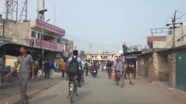 Chandigarh, 26 Haziran 2024. Chandigarh Havalimanı yakınlarındaki Kandala Phirni yakınlarındaki Zirakpur Yolu 'nun köy yakasında bisiklet ve motosikletle işe giden kadın ve erkeklerin sabah koşuşturması. Bir taksiden görüntü