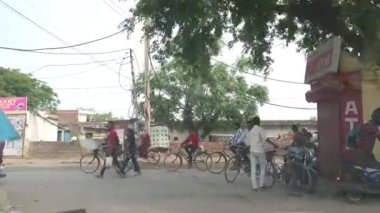 Chandigarh, 26 Haziran 2024. Chandigarh Havalimanı yakınlarındaki Kandala Phirni yakınlarındaki Zirakpur Yolu 'nun köy yakasında bisiklet ve motosikletle işe giden kadın ve erkeklerin sabah koşuşturması. Bir taksiden görüntü
