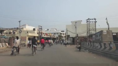 Chandigarh, 26 Haziran 2024. Chandigarh Havalimanı yakınlarındaki Kandala Phirni yakınlarındaki Zirakpur Yolu 'nun köy yakasında bisiklet ve motosikletle işe giden kadın ve erkeklerin sabah koşuşturması. Bir taksiden görüntü