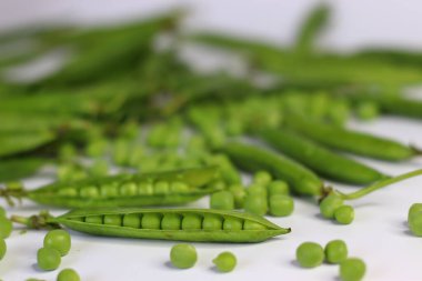 Arkaplanda yeşil bezelye kabukları ve bezelye kabukları olan açık bezelye kabukları. Taze, organik ürünler sergileniyor. Yemek blogları, yemek tarifleri, sağlıklı beslenme ve beslenme içeriği için mükemmel.