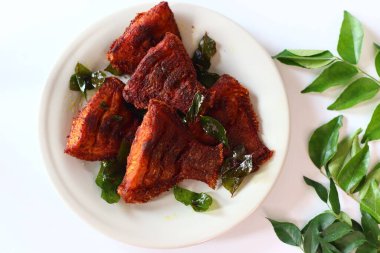 Vietnam inci benekli balığı aromatik baharatlarla marine edilmiş ve altın mükemmelliğinde kızartılmış taze köri yapraklarıyla süslenmiş. Yukarıdan aşağıya doğru, zengin dokusunu ve canlı tonlarını vurguluyor.