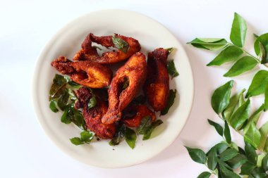 Vietnam inci benekli balığı aromatik baharatlarla marine edilmiş ve altın mükemmelliğinde kızartılmış taze köri yapraklarıyla süslenmiş. Yukarıdan aşağıya doğru, zengin dokusunu ve canlı tonlarını vurguluyor.