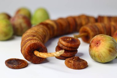 Beyaz arka planda kurumuş ve taze incir renkleri ve dokuları vurgulanıyor. Lifli, antioksidanlı ve mineralli ürünler sindirime ve sağlığa yardımcı olur. Yemek blogları ve dergiler için ideal.