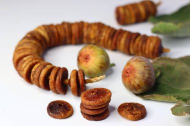 Beyaz arka planda kurumuş ve taze incir renkleri ve dokuları vurgulanıyor. Lifli, antioksidanlı ve mineralli ürünler sindirime ve sağlığa yardımcı olur. Yemek blogları ve dergiler için ideal.