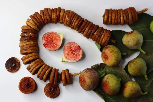 Beyaz arka planda kurumuş ve taze incir renkleri ve dokuları vurgulanıyor. Lifli, antioksidanlı ve mineralli ürünler sindirime ve sağlığa yardımcı olur. Yemek blogları ve dergiler için ideal.