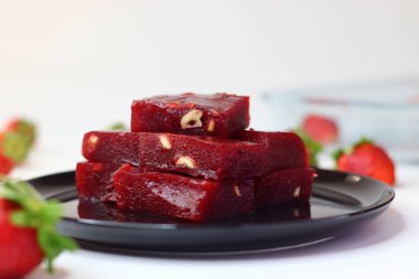 Çilekli halwa, pürüzsüz bir Hint tatlısı ve pembe bir tonu var. Geleneksel bir kasede servis edilir, parlak bir dokusu vardır ve doğranmış fındıkla süslenir. Lezzetli, neşeli ve çekici bir ziyafet.