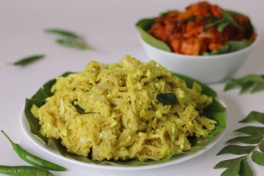 Tavuk Masala Curry ile Chakka Vevichathu. Kerala soslu hindistan cevizi, zerdeçal ve baharatlı karabuğday ezmesi, Kerala usulü köri soslu tavuk. Çekim özgün sunumu yakalar.