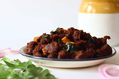 Kerala Biftek Kızartması. Baharatlı marine edilmiş biftekle yapılan lezzetli bir Güney Hint yemeği soğan, sarımsak, köri yaprağı ve çıtır hindistan cevizi gevreğiyle yavaş yavaş pişiriliyor.