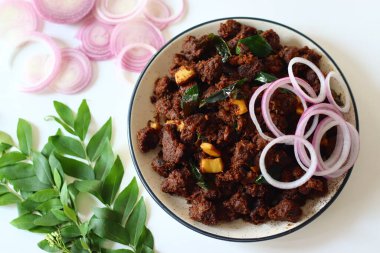 Kerala Biftek Kızartması. Baharatlı marine edilmiş biftekle yapılan lezzetli bir Güney Hint yemeği soğan, sarımsak, köri yaprağı ve çıtır hindistan cevizi gevreğiyle yavaş yavaş pişiriliyor.