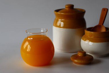 Ev yapımı İnek Ghee. Süt katı maddeleri ve su buharlaşana kadar yavaş ısıtılan tereyağı ile yapılan berrak bir tereyağı zengin bir aroması ve derin bir tadı olan altın, berrak bir sıvı oluşturur. Cam şişelerde depolanmış.