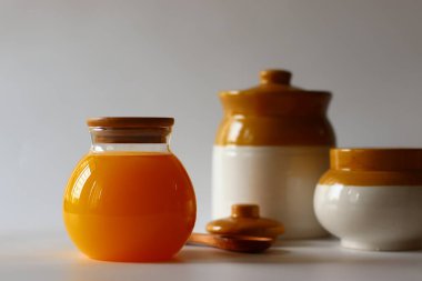 Ev yapımı İnek Ghee. Süt katı maddeleri ve su buharlaşana kadar yavaş ısıtılan tereyağı ile yapılan berrak bir tereyağı zengin bir aroması ve derin bir tadı olan altın, berrak bir sıvı oluşturur. Cam şişelerde depolanmış.