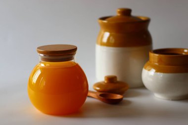 Ev yapımı İnek Ghee. Süt katı maddeleri ve su buharlaşana kadar yavaş ısıtılan tereyağı ile yapılan berrak bir tereyağı zengin bir aroması ve derin bir tadı olan altın, berrak bir sıvı oluşturur. Cam şişelerde depolanmış.