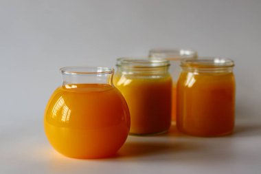 Ev yapımı İnek Ghee. Süt katı maddeleri ve su buharlaşana kadar yavaş ısıtılan tereyağı ile yapılan berrak bir tereyağı zengin bir aroması ve derin bir tadı olan altın, berrak bir sıvı oluşturur. Cam şişelerde depolanmış.