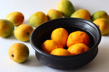 Kerala usulü körili yoğurt, hindistan cevizi ve baharatla pişirilmeye hazır toprakta soyulmuş mangolar. Adı Mango Pulisheri, ayrıca olgun mangolu yoğurt körisi, Kerala usulü mango körisi.