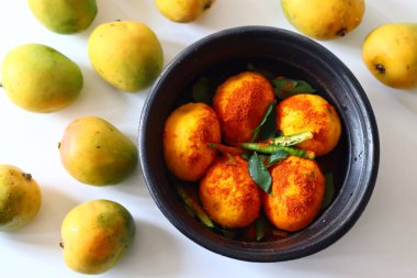 Çili tozu ve baharatla saçılmış toprakta soyulmuş mangolar hindistan cevizi ve lor peyniri ile Kerala köri için hazırlanıyor. Adı Mango Pulisheri, ayrıca olgun mango körili yoğurt, mango körili.