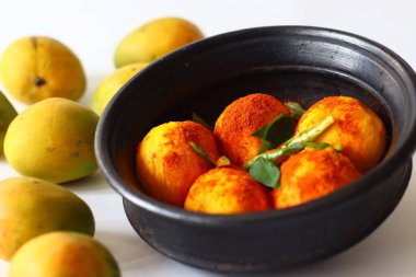 Çili tozu ve baharatla saçılmış toprakta soyulmuş mangolar hindistan cevizi ve lor peyniri ile Kerala köri için hazırlanıyor. Adı Mango Pulisheri, ayrıca olgun mango körili yoğurt, mango körili.