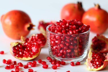 - Nar. Beyaz bir yüzeyde parlak kırmızı şeritli açık meyve, yumuşak doğal ışıkla yakalanır. Antioksidan, C vitamini ve lif açısından zengin. Kalp sağlığını ve sindirimi destekliyor.
