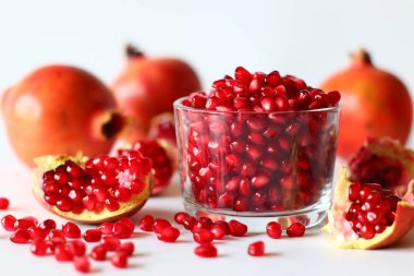 - Nar. Beyaz bir yüzeyde parlak kırmızı şeritli açık meyve, yumuşak doğal ışıkla yakalanır. Antioksidan, C vitamini ve lif açısından zengin. Kalp sağlığını ve sindirimi destekliyor.