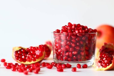 - Nar. Beyaz bir yüzeyde parlak kırmızı şeritli açık meyve, yumuşak doğal ışıkla yakalanır. Antioksidan, C vitamini ve lif açısından zengin. Kalp sağlığını ve sindirimi destekliyor.