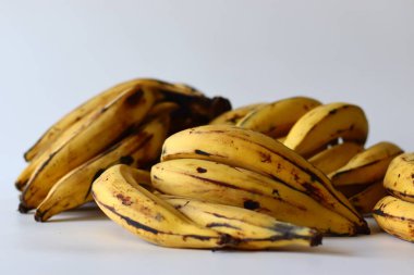 Kerala Plantains. Altın sarısı derili ve koyu benekli olgun bir grup Nendran muzu. Zengin lezzeti ve sert dokusuyla bilinir. Etakka veya vazhakka olarak da adlandırılan tropik bir Güney Hint meyvesi.