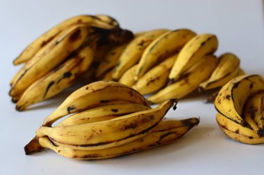 Kerala Plantains. Altın sarısı derili ve koyu benekli olgun bir grup Nendran muzu. Zengin lezzeti ve sert dokusuyla bilinir. Etakka veya vazhakka olarak da adlandırılan tropik bir Güney Hint meyvesi.