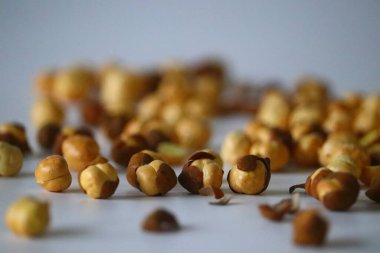 Crispy Roasted Channa chickpeas scattered on white background. Perfect for Indian snacks, protein rich diets, and healthy eating themes. Ideal for clean eating and vegan food imagery