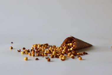Crispy Roasted Channa chickpeas in a newspaper cone, scattered on white background. Perfect for Indian snacks, protein rich diets, healthy eating themes. Ideal for clean eating and vegan food image