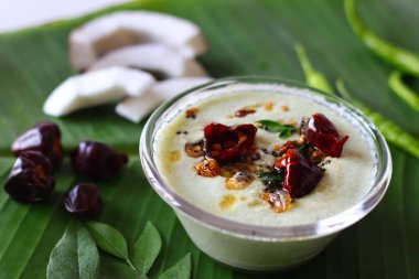 Hindistan cevizi dilimleri, yeşil biber ve köri yapraklarıyla süslenmiş iki kase baharatlı hindistan cevizi turşusu. Canlı bir vegan dostu Güney Hindistan refakatçisi Ayurvedic temalı conten için iyi